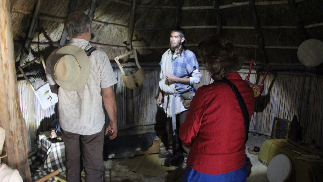 Dans la pénombre de la hutte du premier âge du Fer, cordes de lyre pincées et accords de flûte de pan.