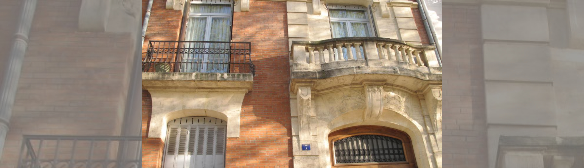 Trame verticale traitée en pierrre au droit de la porte d'entrée : balcon à balustres,pilastres et corniches