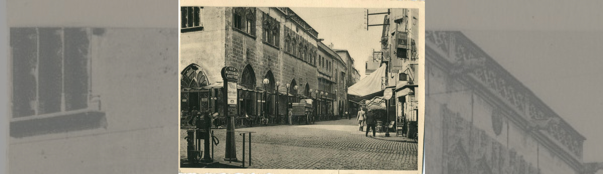 Carte postale ancienne de la place montrant un arrêt d'autobus, une rue pavée , un balcon en façade de l'hotel de ville