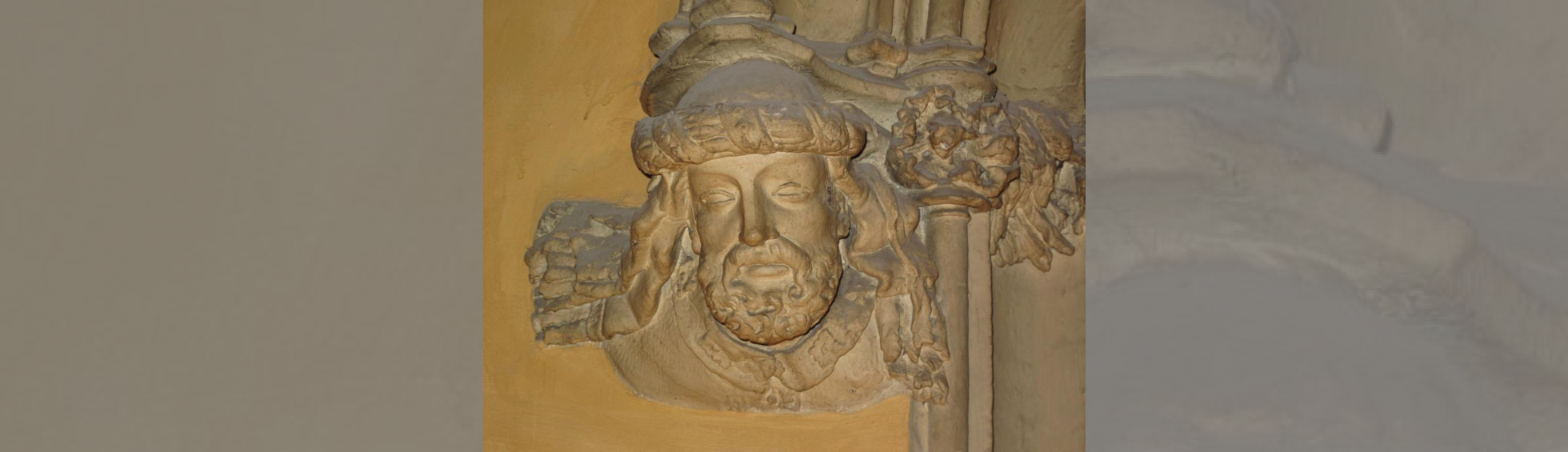 Tête décorative de Bernat Xanxo à la base d'un encadrement de porte côté gauche