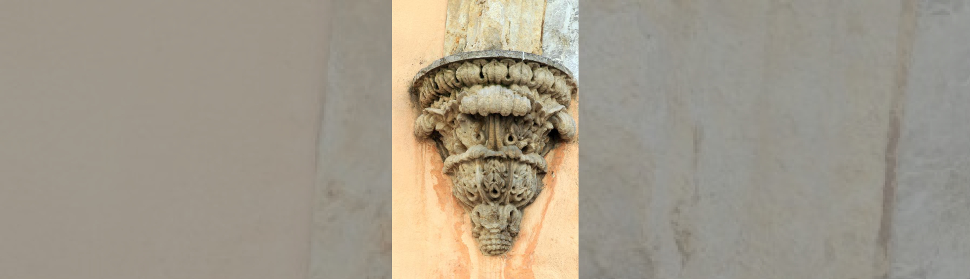 Retombée de l'arc du portail d'entrée formée d'un culot en forme de cône décorée de feuilles enroulées.