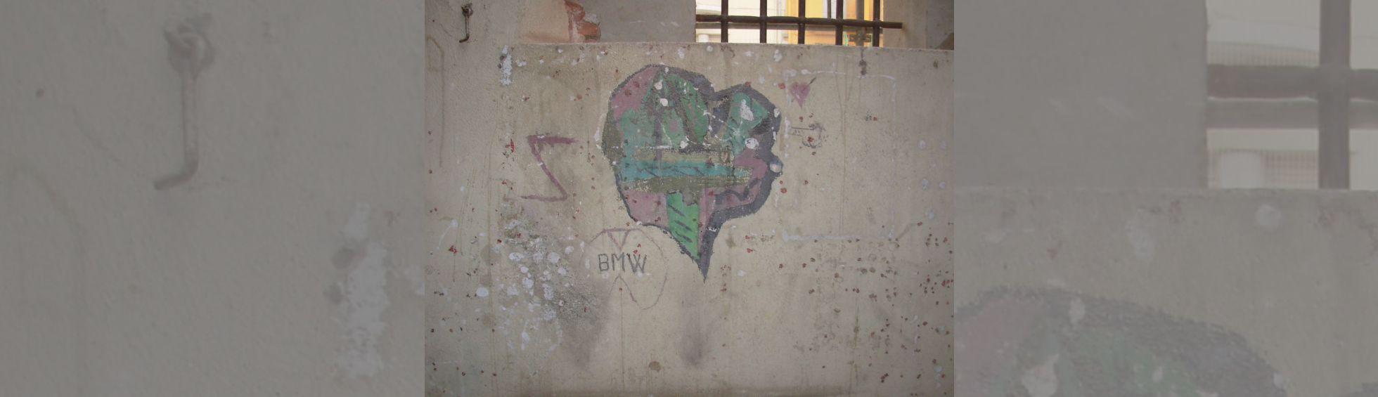 Graffiti dans une cellule de la prison représentant un coeur coloréet et la marque BMW 